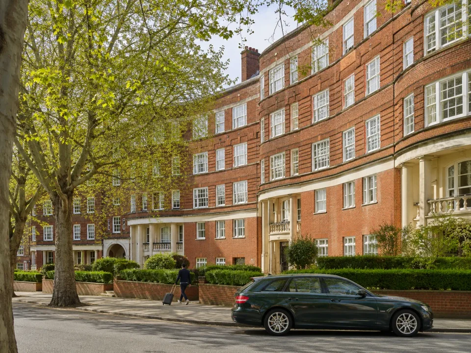 Executive estate car beside the curved red-brick Art Deco architecture of Balham
