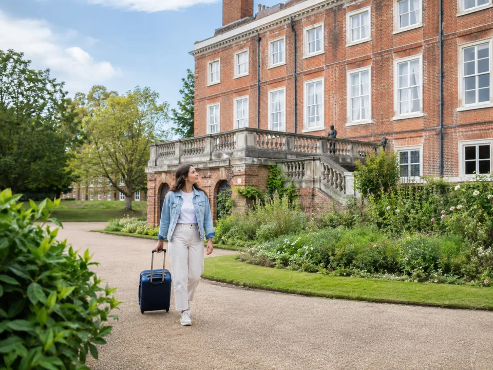 Traveller with a suitcase in the gardens beside Valence House in Dagenham