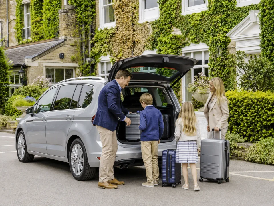 Chauffeur loading family luggage into a premium people carrier in Esher