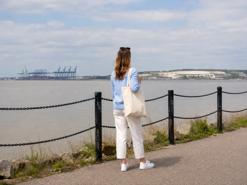 Visitor overlooking the Thames estuary and distant port cranes from Grays