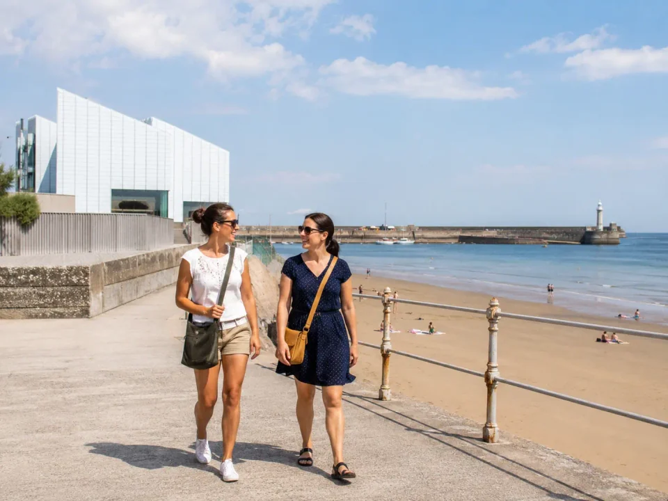 Women visitors walking on Margate seafront beside the harbour and gallery
