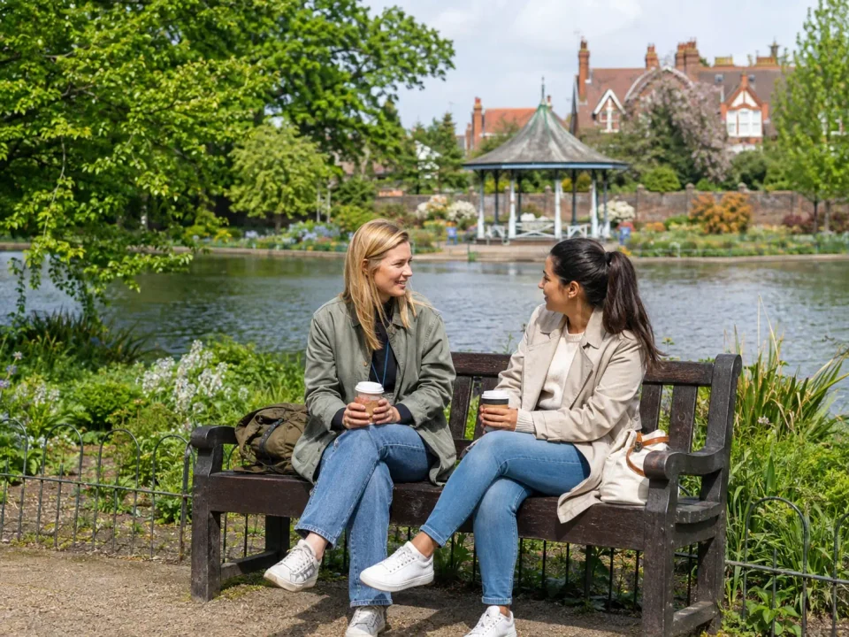 Travellers having coffee beside the lake and bandstand in Broomfield Park, Palmers Green