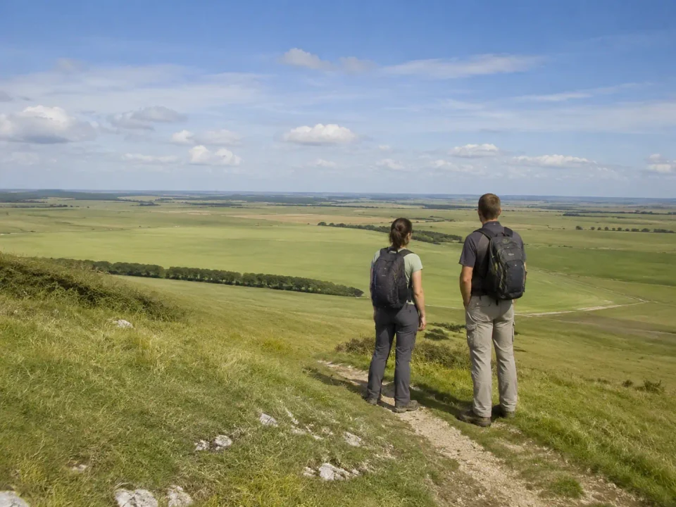 Hikers with backpacks overlooking the chalk grassland of Salisbury Plain