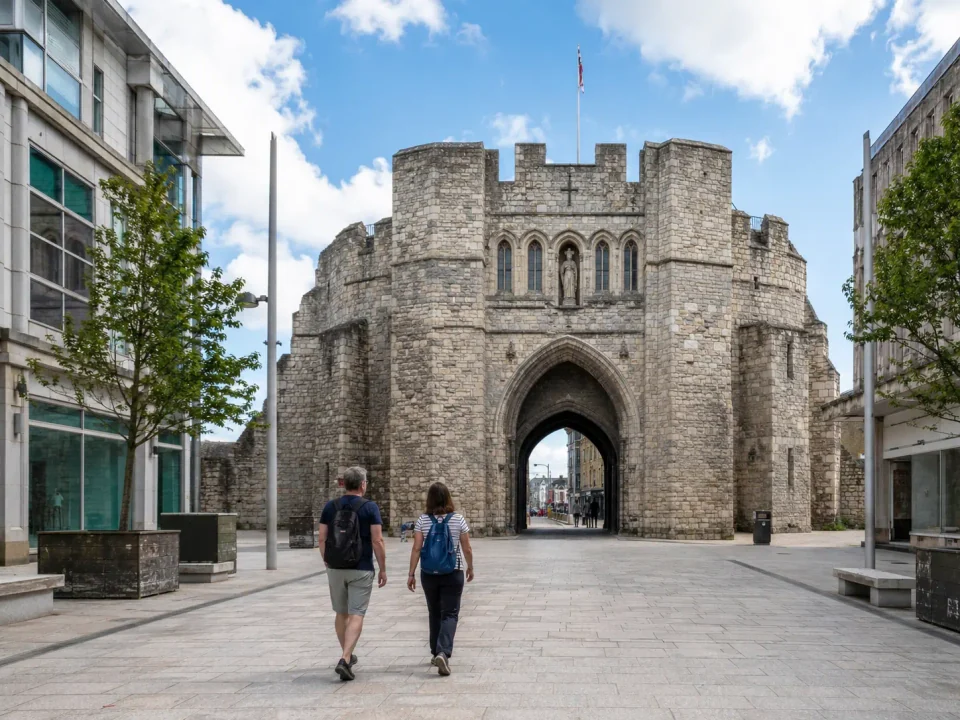 Travelling couple walking through the medieval Bargate in Southampton
