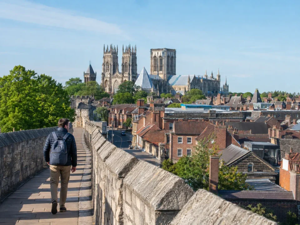 Traveller walking along York city walls towards York Minster