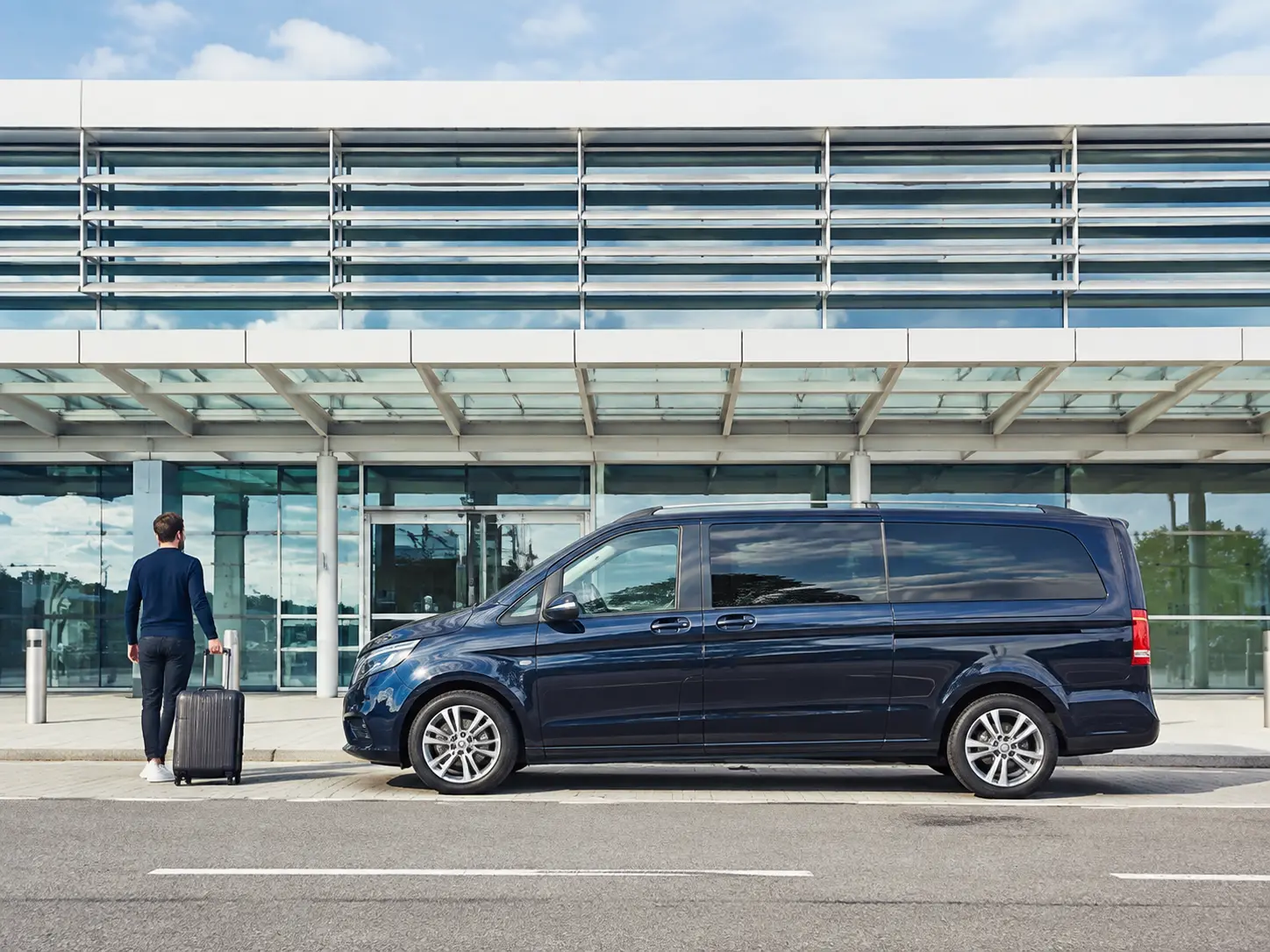 Traveller beside a premium people carrier at Gatwick North Terminal