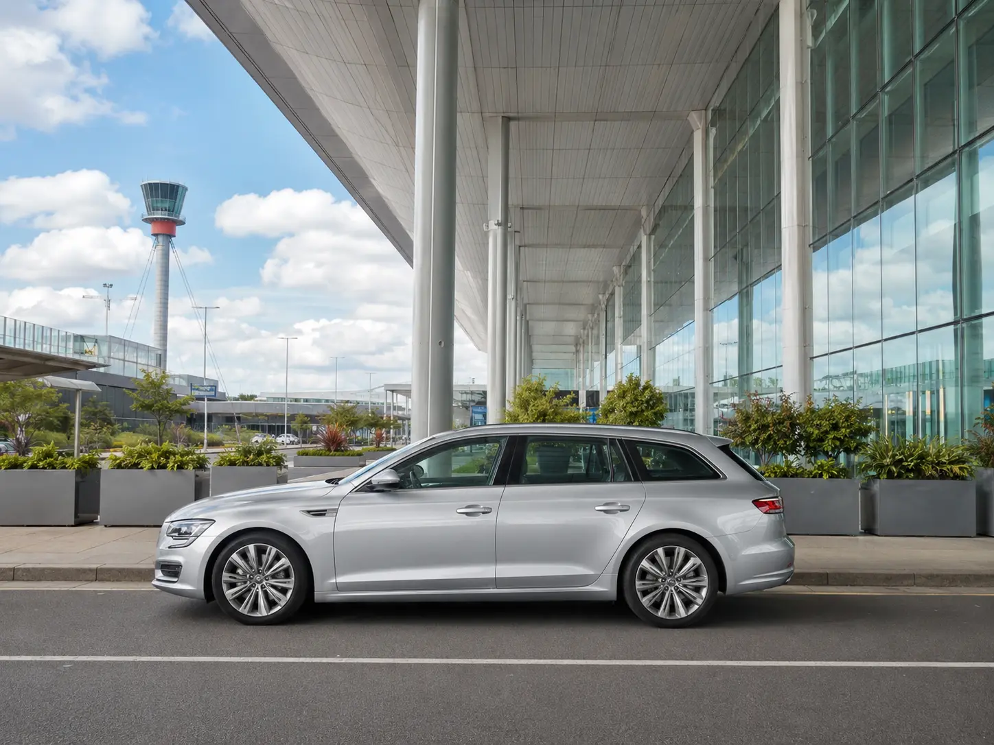 Executive estate car outside the glass frontage of Heathrow Terminal 4