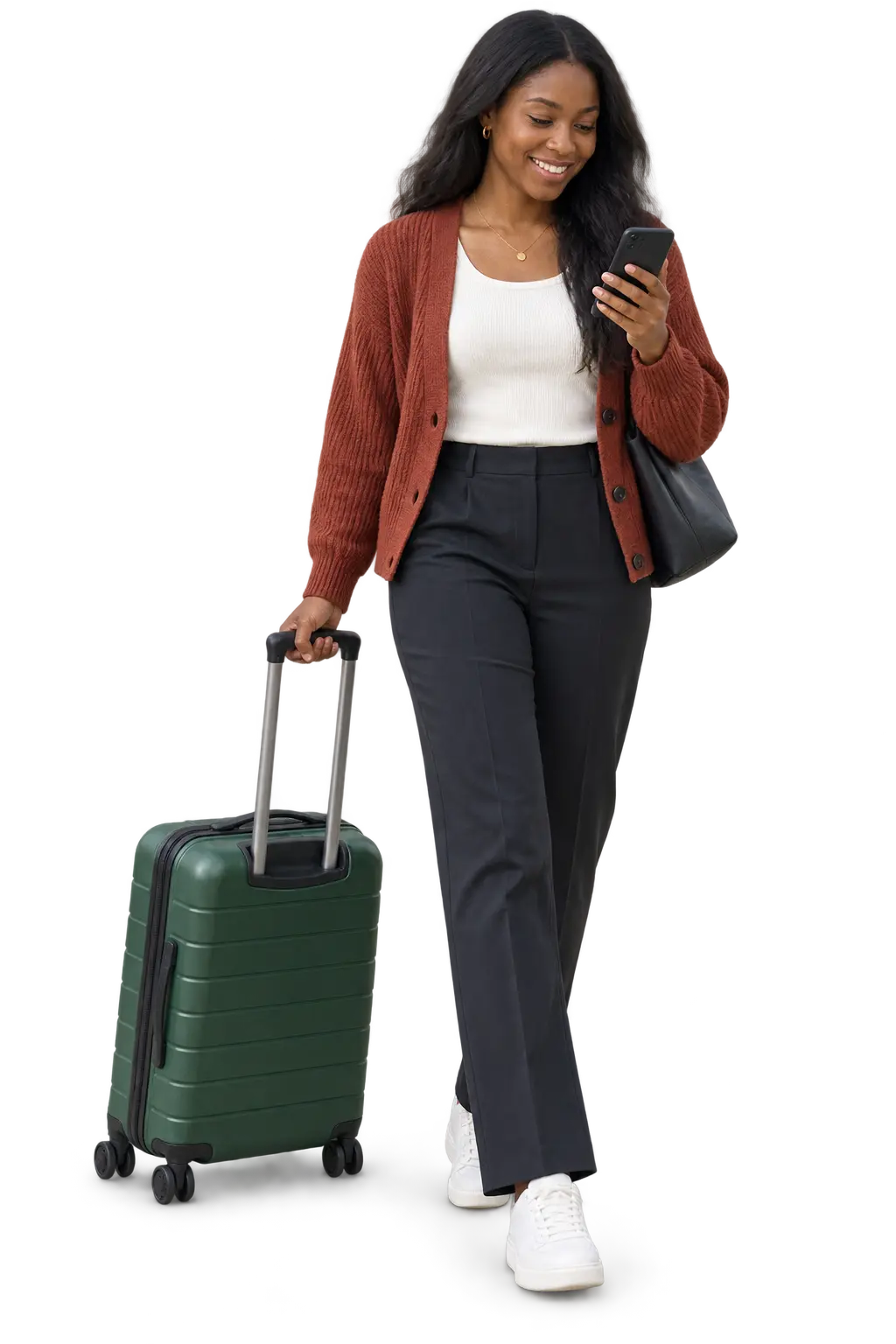 Traveller checking her phone while pulling a green suitcase