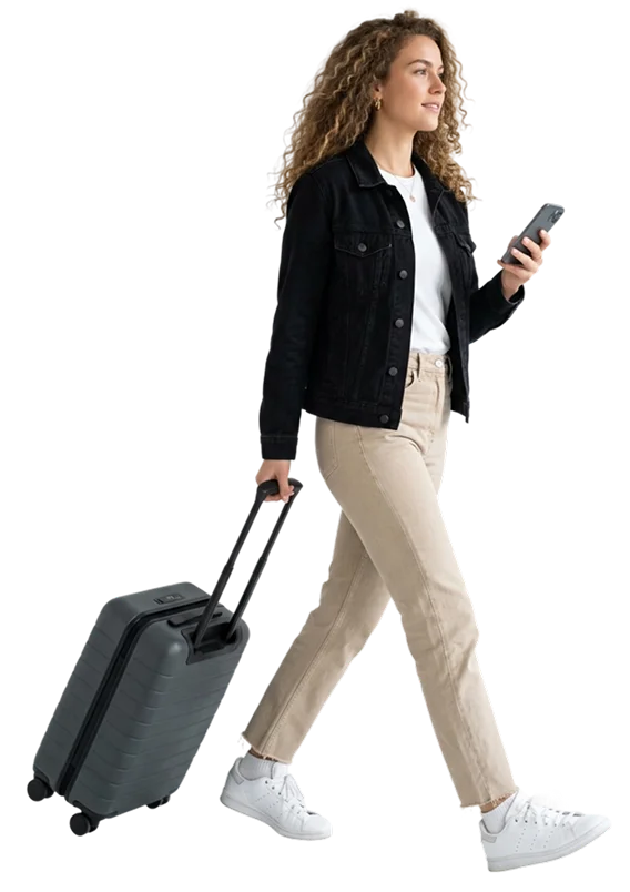 Woman walking with suitcase using phone